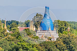 Remnants of ancient town Inwa (Ava) near Mandalay, Myanmar. Lawka Tharahpu Pagoda under scaffolding visibl