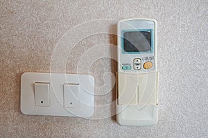 Remote control of air conditioner and light switch on the bedroom wall