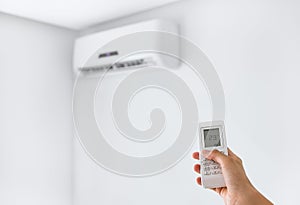 Remote control for air conditioner on a white wall.