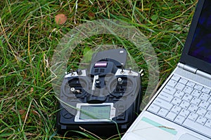 Remote control and laptop are on the green grass