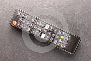 One TV remote on a slate rock , macro shot, top view.