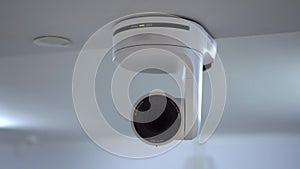 The remote controlled camera uses an electromechanical optical zoom. A white camera hangs from the ceiling in the room