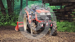 A remote-controlled minitractor loosens the soil for the lawn. Land works