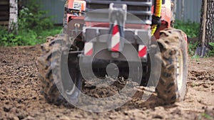 A remote-controlled minitractor loosens the soil for the lawn. Land works