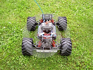 Remote-controlled model of off-road car with electric motor, without cover, back view