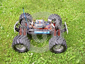 Remote-controlled model of off-road car with electric motor, without cover, side view