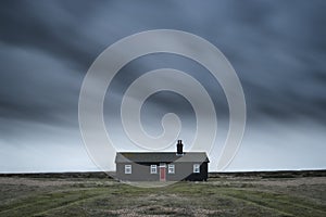 Remote desolate isolated house under dark stormy sky during Wint