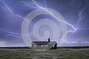 Remote desolate isolated house under dark stormy sky during Winter landscape conceptual image