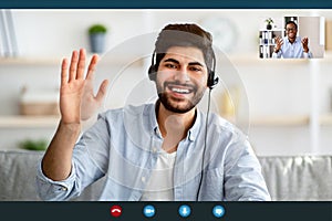 Remote distant communication. Arab man in headphones having video online conference with colleague, monitor screenshot