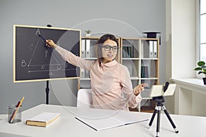 Young college or school teacher giving online lesson, using smartphone with tripod