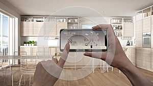 Remote home control system on a digital smart phone tablet. Device with app icons. Interior of minimalist white and wooden kitchen