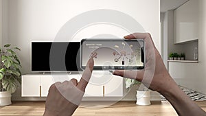 Remote home control system on a digital smart phone tablet. Device with app icons. Interior of minimalist white and wooden living