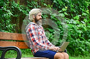 Remote job. Online shopping. Agile business. Bearded guy sit bench park nature background. Work and relax. Working