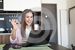 Remote job, technology and people concept. Happy smiling young woman with laptop computer having video call and waving hand at