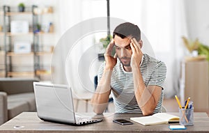 Stressed man with laptop working at home office