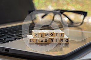 REMOTE LEARNING virtual learning concept with wood block letters on laptop