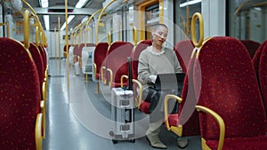 Remote manager working train waiting trip start. Short hair woman zooming tablet