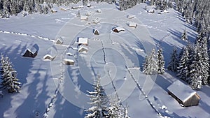 Remote mountain village, homestead in the mountains covered by snow at winter. Aerial drone view