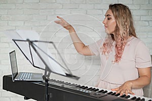 Remote music lessons. A singing teacher records the lesson on a laptop webcam.