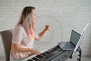 Remote music lessons. A singing teacher records the lesson on a laptop webcam.