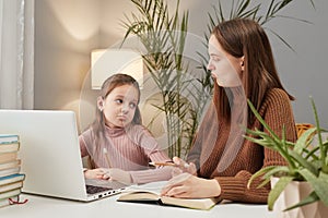 Remote schooling support for parents. Sad mother and upset daughter using laptop for doing homework feeling uninterest to school