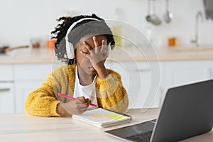 Remote Study Stress. Sad Black Little Girl Sitting At Desk With Laptop