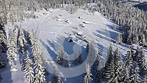 Remote village, homestead, houses buried under snow in the mountains. Aerial drone view