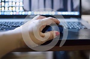 Remote work. Close-up of a female hand holding a computer mouse