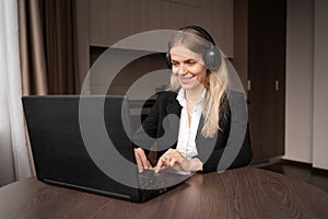 remote work concept. Caucasian woman in headphones works remotely on her laptop, freelancer or teacher has a video call