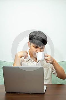 Remote work concept, Male freelancer drinking coffee to relaxation after working on laptop at home