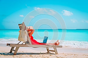 Remote work concept -young woman with laptop on beach
