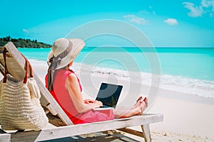 Remote work concept -young woman with laptop on beach