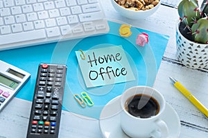 Remote work at home during the Coronavirus epidemic. A card with the words `Home Office` and a cup of coffee, TV remote control, o