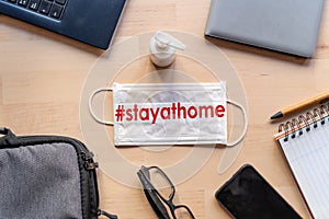 Remote work kit on wooden office desk with hand sanitizer and face mask, a solution against the spread of corona virus for photo