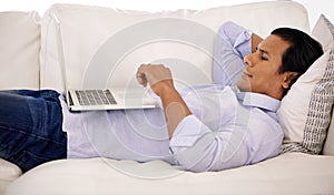 Remote work, laptop and businessman relax on sofa streaming, video or social media at home. Pc, search or freelancer in