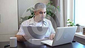 Remote Work - Man Reviewing Business Papers at Home Office