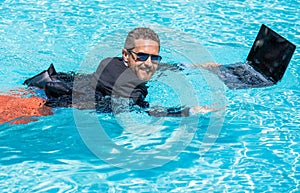 Remote working. Summer business dreams. successful man. Businessman in suit with laptop in swimming pool. business man