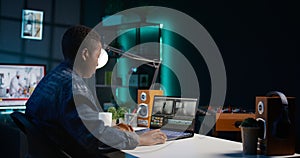 Remotely working videographer doing video montage using specialized software