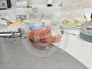 Removable dentures are demonstrated by a doctor in a dental laboratory