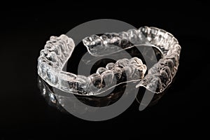 Removable plastic retainers for bite correction on a black background