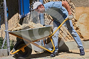 Removal of construction debris by wheelbarrow,man pushes a full wheelbarrow of construction debris