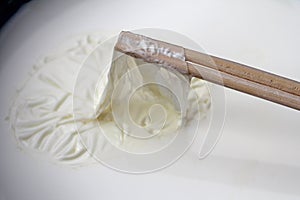 Remove milk skin from the surface of the milk with wooden sticks