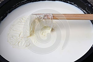 Remove milk skin from the surface of the milk with wooden sticks