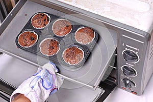 Remove the muffins from the oven using gloves panggang adonan kue