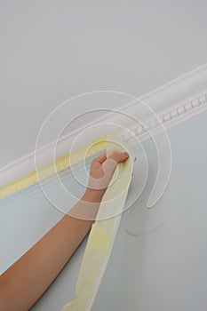 Remove paper masking tape from after painting. Removing masking tape from wall.