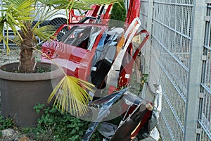 Removed and scrapped various colored car doors leaned against metal meshed wire fence. photo