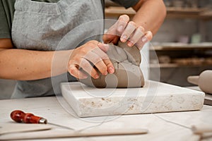 Removing air bubbles from clay before modeling to avoid the ruination of a ceramic product. Wedging the clay before