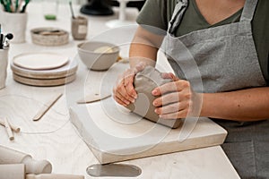 Removing air bubbles from clay before modeling to avoid the ruination of a ceramic product. Wedging the clay before