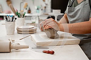 Removing air bubbles from clay before modeling to avoid the ruination of a ceramic product. Wedging the clay before