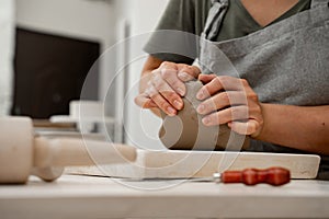 Removing air bubbles from clay before modeling to avoid the ruination of a ceramic product. Wedging the clay before